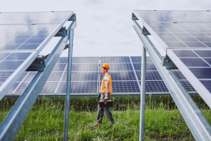 Man worker in the firld by the solar panels solar panel systems